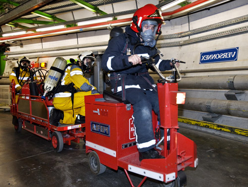 Французские, швейцарские пожарные с аварийно-спасательным оборудованием двигаются через туннель Большого Андронного коллайдера